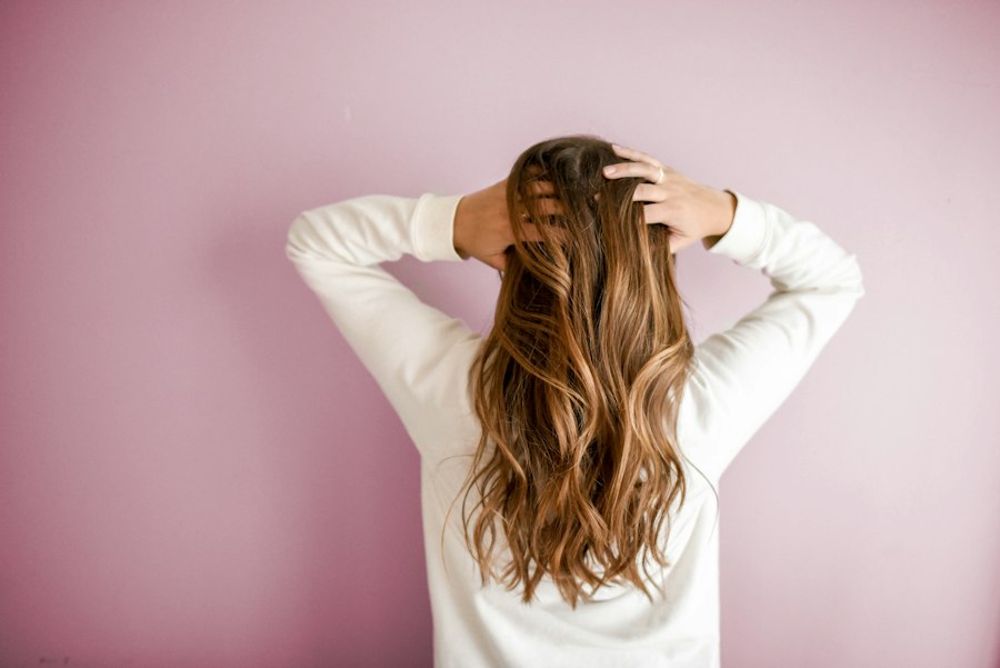 Long brown waves against a pink wall